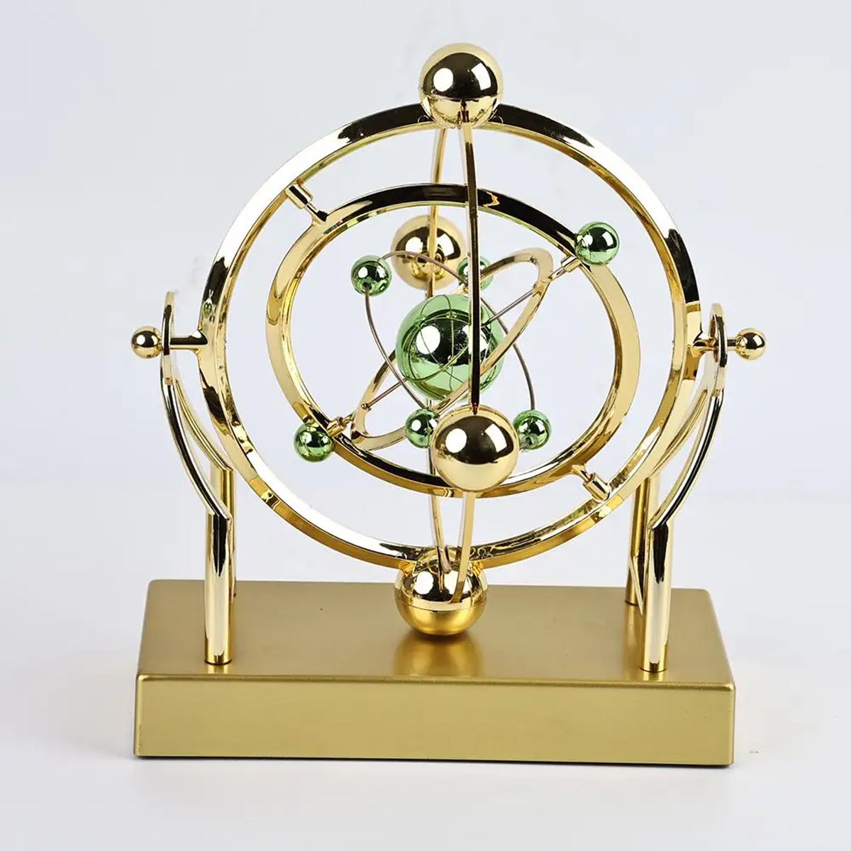 Golden kinetic orbit desk display with elegant motion sculpture