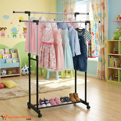 A black metal two-bar clothing rack with a lower shoe shelf, shown in a colorful children's bedroom. Several children's dresses and shirts are hanging on the rack, along with a pair of jeans.