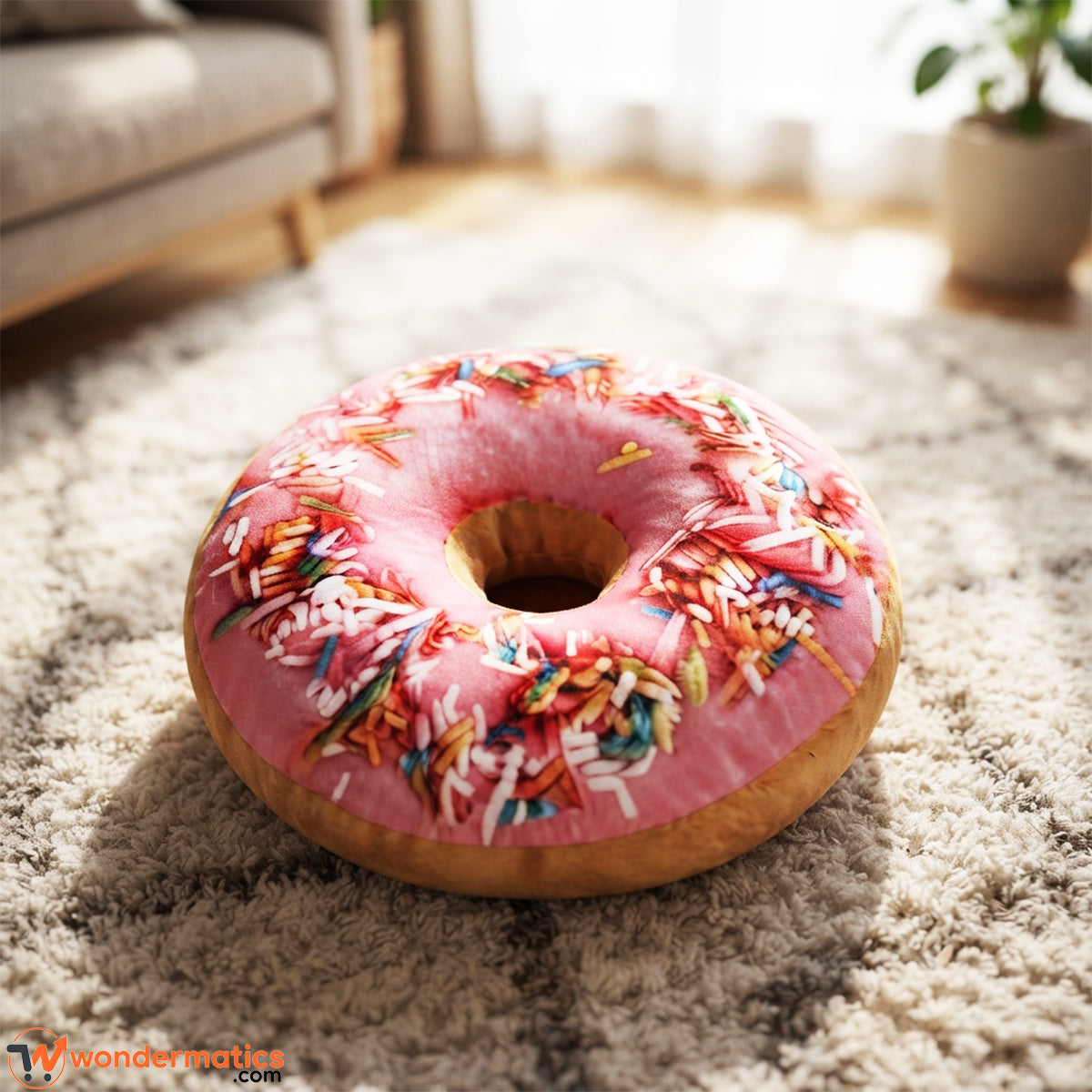 Front view of round donut shaped plush floor cushion pink color