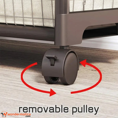 Close-up of a dark brown rolling wheel under a bed frame on a wood floor, with red arrows and the text 'removable pulley' to explain the feature. A wondermatics.