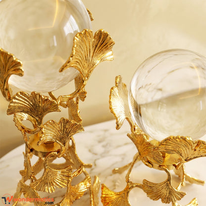 Side angle of a golden ginkgo leaf crystal ball showpiece showing layered metal leaves