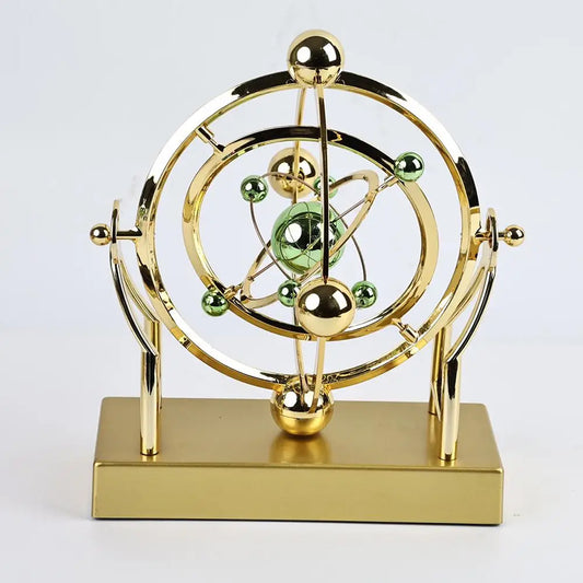 Golden kinetic orbit desk display with elegant motion sculpture