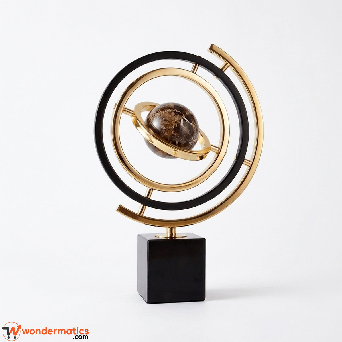 A modern decorative sculpture featuring a gold and black metallic orbit design with a brown gemstone planet at the center, mounted on a black square base against a white background.