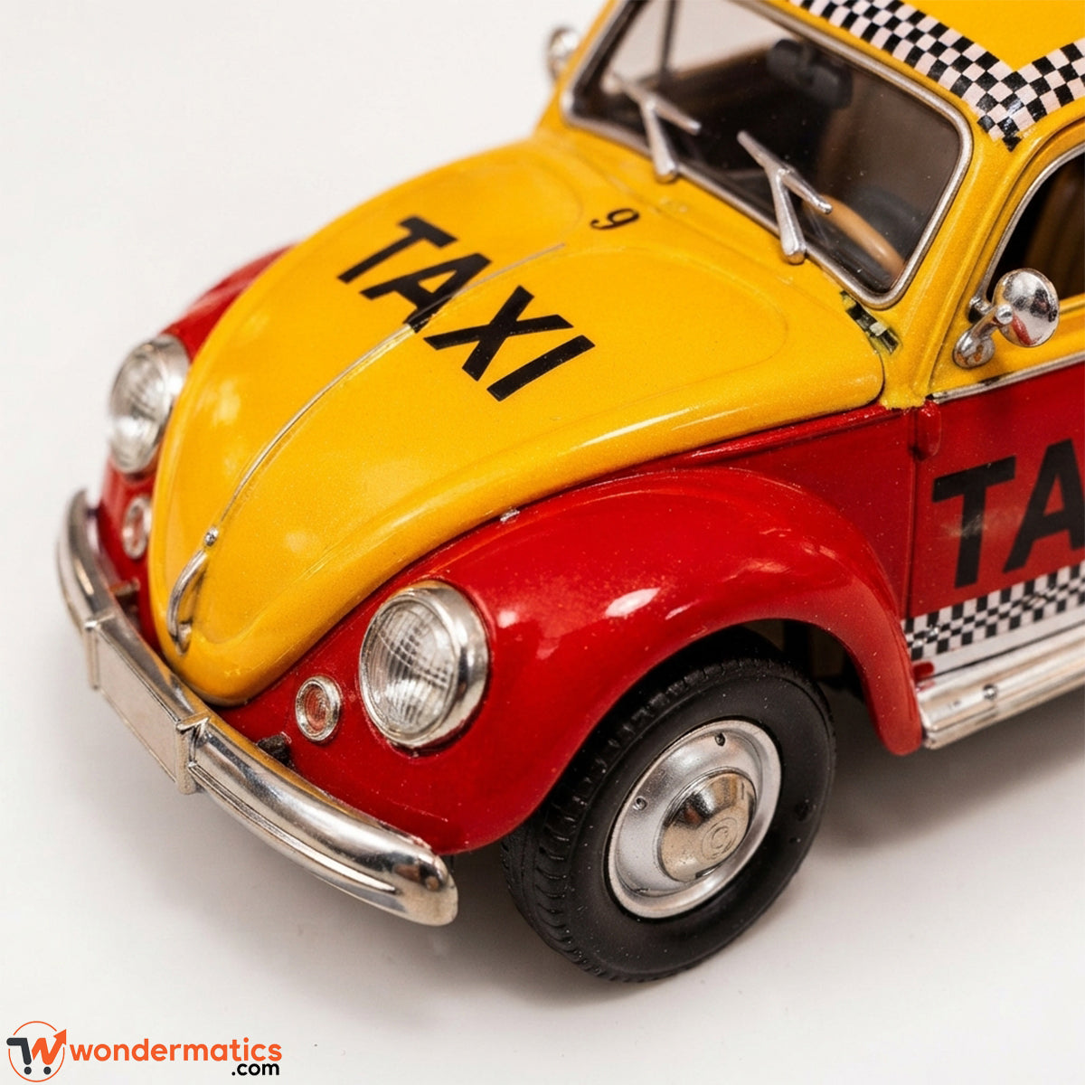 A close-up of a vintage-style decorative car resembling a Volkswagen Beetle, painted yellow and red with black 'TAXI' lettering and a black-and-white checkered roof and side detail, photographed on a white background.