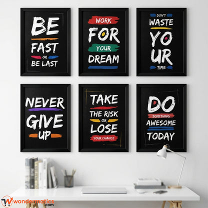 Six framed motivational wall art prints with white text on black backgrounds are displayed above a white desk in a bright room. The quotes include 'BE FAST OR BE LAST', 'WORK FOR YOUR DREAM', 'DON'T WASTE YOUR TIME', 'NEVER GIVE UP', 'TAKE THE RISK OR LOSE YOUR CHANCE', and 'DO SOMETHING AWESOME TODAY'.