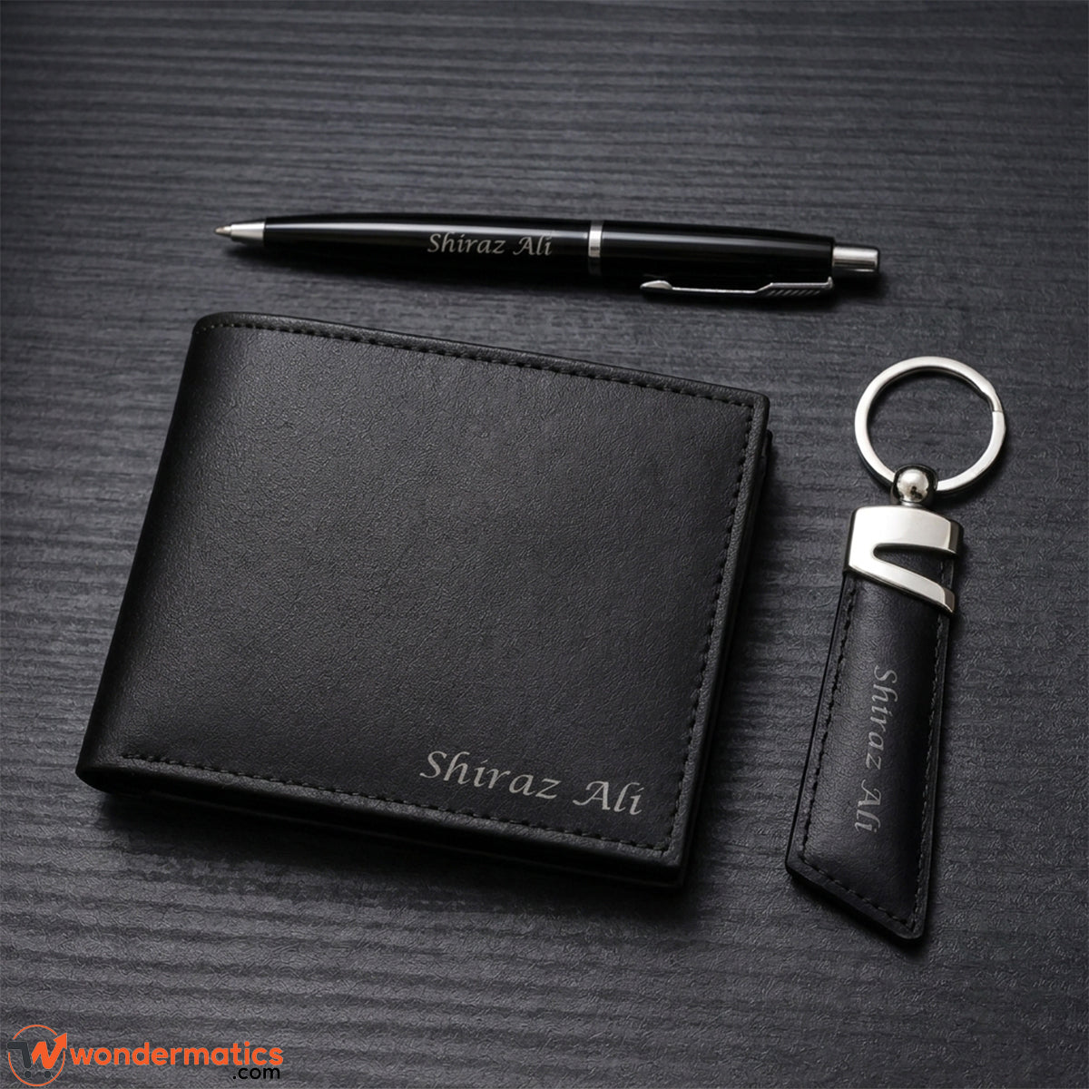 Flat lay of wallet, keyring and pen gift set arranged together