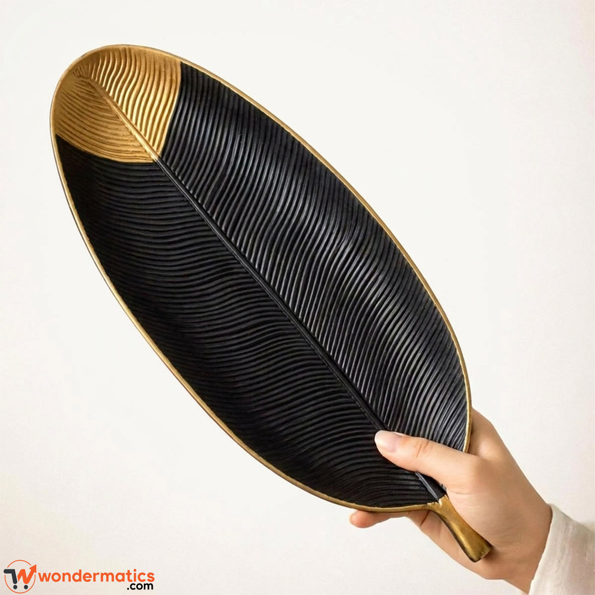 Wooden leaf shape decorative tray in black and gold on white background